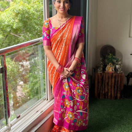 Woman in a colorful saree standing by a window with greenery outside