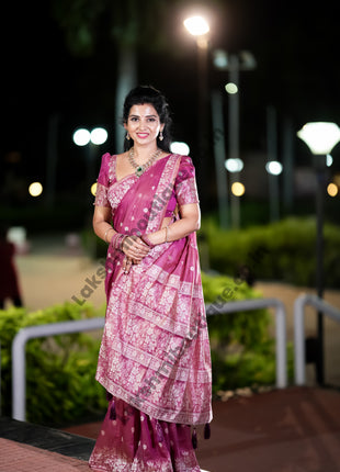 Woman in a pink saree with a dark background